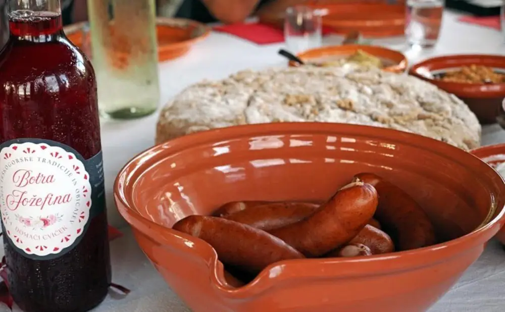 Kranjska kobasica, potica i domaći proizvodi posluženi uz cviček tijekom vinske ture.