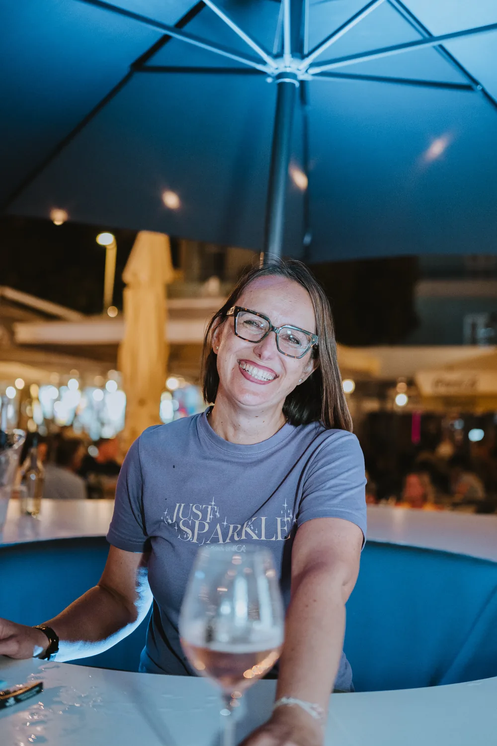 Zadovoljna posjetiteljica s čašom pjenušca u majici Just Sparkle na festivalu u Crikvenici