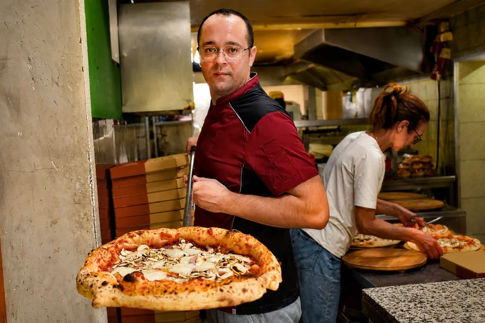 Pizzaiolo Matej Topić s pizzom iz krušne peći u kuhinji bistroa Kaktus